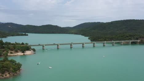 Bridge-with-cars-crossing-the-lake-Saint-cassien-aerial-shot-large-reservoir